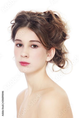 Portrait of young beautiful girl with clean makeup and prom hairdo