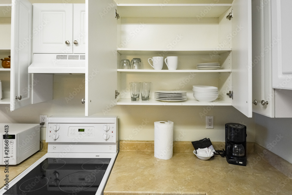Open cabinets and primary appliances on average home kitchen. Open cabinets and primary appliances on average home kitchen.