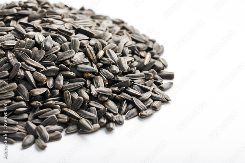 Seeds in a black shell are a bunch on a white background. In full screen Seeds in a black shell are a bunch on a white background. In full screen