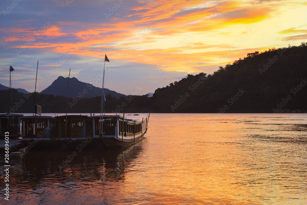Fototapeta premium Boats on Mekong river with colorful sunset sky in Luang Prabang, Laos