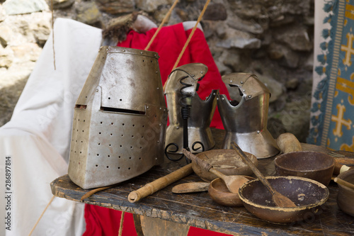 Medieval 12th century closed helmet or great helm and gauntlets with eating utensils in a re-enactment camp photo