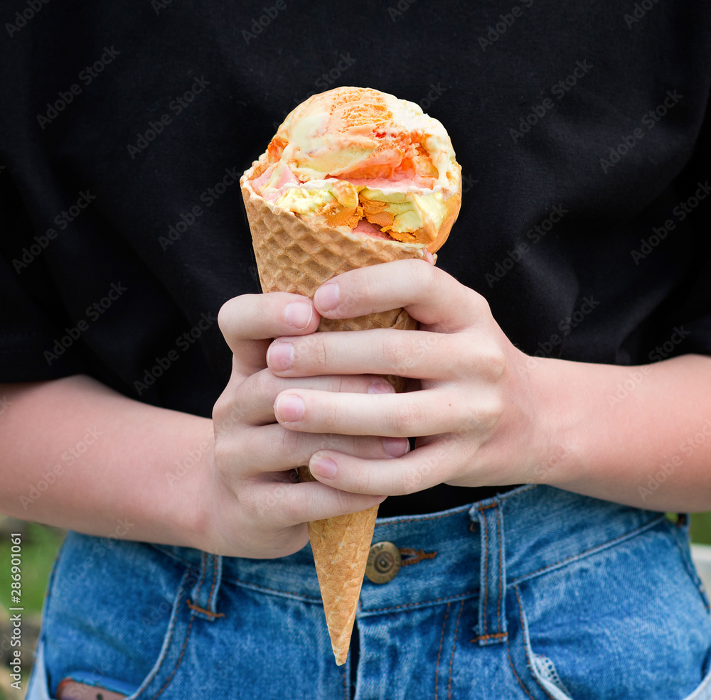Fruit ice cream in the hands of a girl. Front view.  
