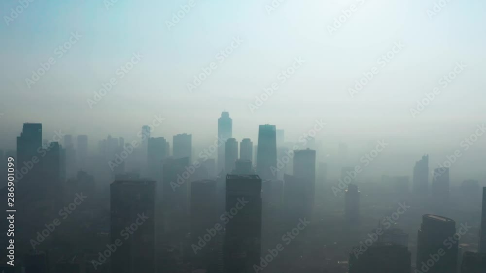 JAKARTA, Indonesia - August 27, 2019: Aerial scenery of dense air pollution smoke on the morning with silhouette of skyscrapers in business district. Shot in 4k resolution from a drone flying forwards JAKARTA, Indonesia - August 27, 2019: Aerial scenery of dense air pollution smoke on the morning with silhouette of skyscrapers in business district. Shot in 4k resolution from a drone flying forwards