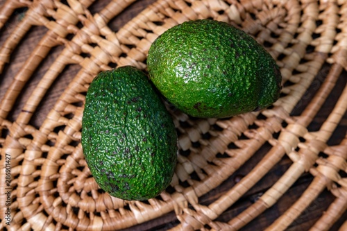 Wallpaper Mural Close up of two green avocados laying on a wicker trivet Torontodigital.ca