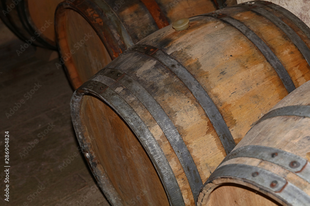 Rows of oak wood wine barrels in winery cellar Rows of oak wood wine barrels in winery cellar
