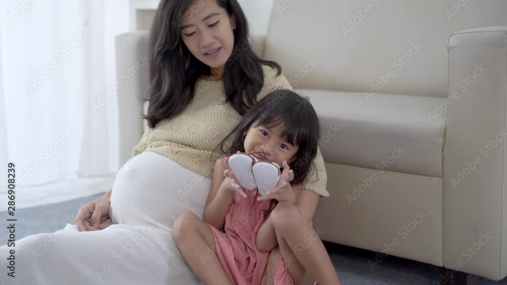 mother and daugther preparing for new baby to be born mother and daugther preparing for new baby to be born