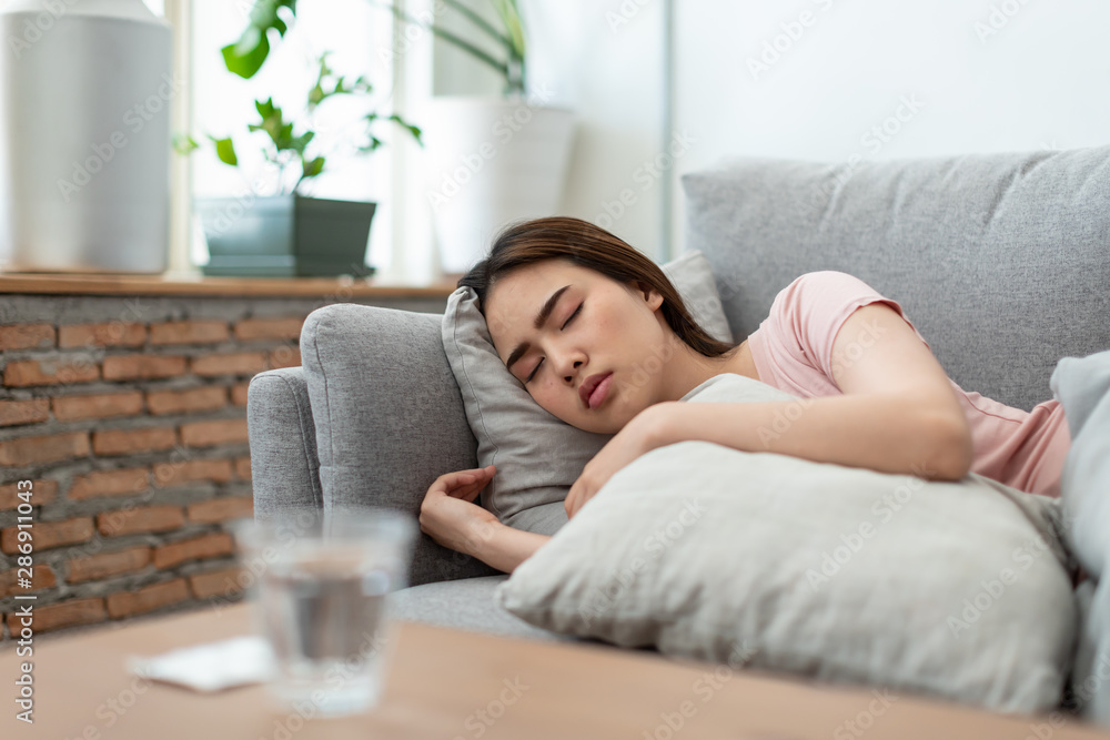 Young woman is sick, unwell, cold and sleep on the sofa. After taking medicine Young woman is sick, unwell, cold and sleep on the sofa. After taking medicine