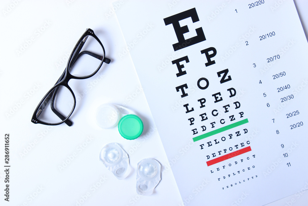 glasses and lenses for vision correction and a table for checking vision on  a light background. Stock Photo | Adobe Stock