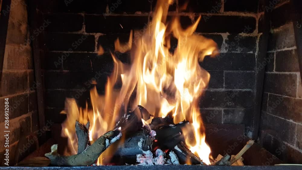high flame burns in the fireplace. burning branches and firewood high flame burns in the fireplace. burning branches and firewood