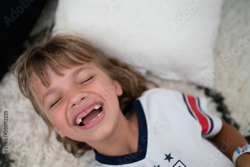 Overhead view of child laughing with missing teeth
