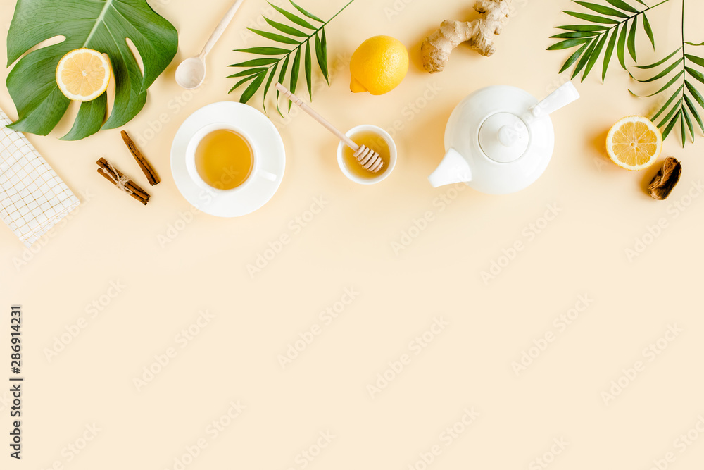 Fototapeta Herbal tea with mint, ginger, lemon, honey and other herbs on yellow background. Flat lay, top view.