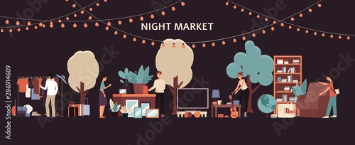 Night market - people buying furniture and clothes at flea garage sale in city park