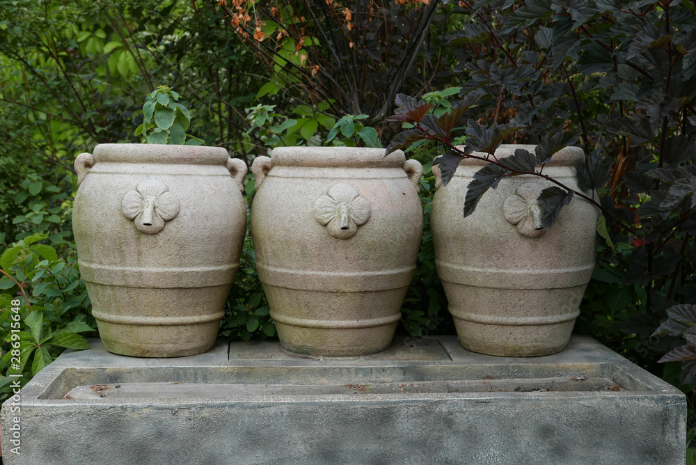 Three beautiful clay pottery vases on the autumn garden Three beautiful clay pottery vases on the autumn garden