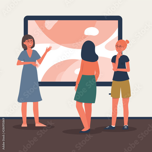 Art gallery tour guide telling two museum visitors about artwork