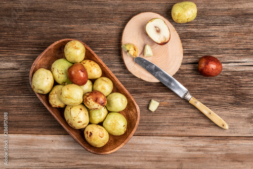 ripe and unripe jujube fruit on cutting board on wooden table