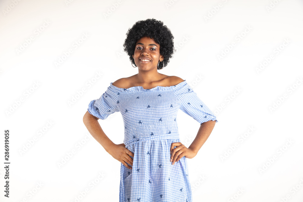 Beautiful female half-length portrait isolated on white studio background. Young emotional african-american woman in blue dress. Facial expression, human emotions concept. Standing and smiling. Beautiful female half-length portrait isolated on white studio background. Young emotional african-american woman in blue dress. Facial expression, human emotions concept. Standing and smiling.