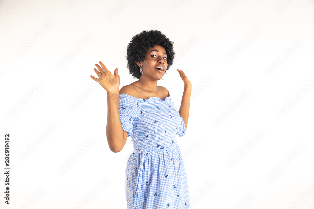 Beautiful female half-length portrait isolated on white studio background. Young emotional african-american woman in blue dress. Facial expression, human emotions concept. Unknowing, uncertainty. Beautiful female half-length portrait isolated on white studio background. Young emotional african-american woman in blue dress. Facial expression, human emotions concept. Unknowing, uncertainty.