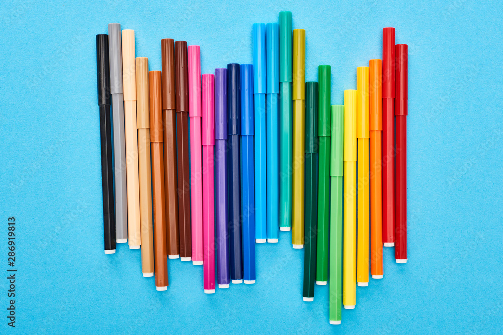 Set of bright colored felt-tip pens isolated on blue Set of bright colored felt-tip pens isolated on blue