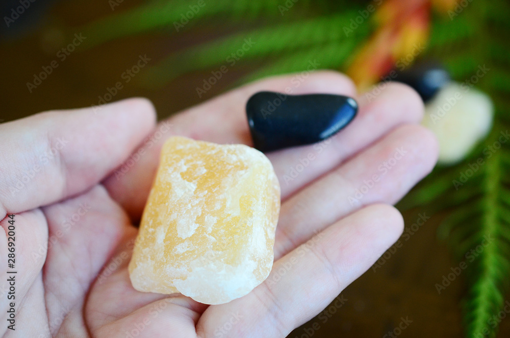 Tumbled Apache Tear and Rough Orange Calcite Duo! Black and Orange, harvest crystals. Witches fall time theme healing crystal bundle. Beautiful, colorful crystal display on wooden table. Natural light