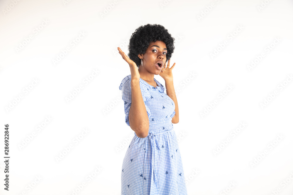 Beautiful female half-length portrait on white studio background. Young emotional african-american woman in blue dress. Facial expression, human emotions concept. Astonished, stylish look. Beautiful female half-length portrait on white studio background. Young emotional african-american woman in blue dress. Facial expression, human emotions concept. Astonished, stylish look.