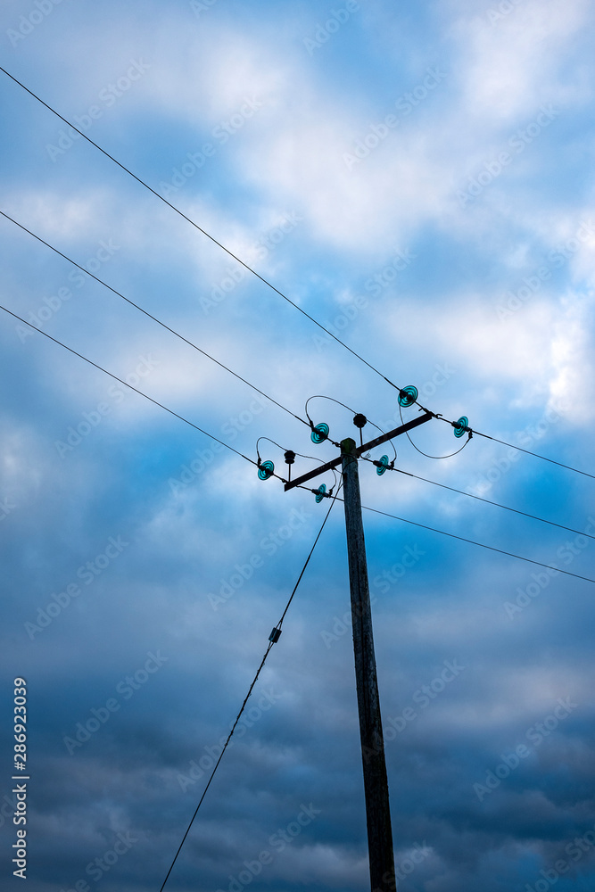 Electricity pole isolated against blue sky with clouds Electricity pole isolated against blue sky with clouds