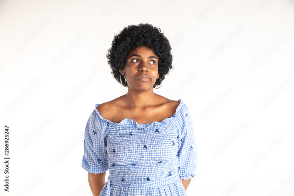 Beautiful female half-length portrait on white studio background. Young emotional african-american woman in blue dress. Facial expression, human emotions concept. Thoughtful, dreaming. Beautiful female half-length portrait on white studio background. Young emotional african-american woman in blue dress. Facial expression, human emotions concept. Thoughtful, dreaming.