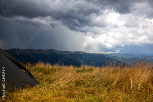 Fototapeta Naklejka Na Ścianę i Meble -  Beautiful mountain landscape in stormy weather with a tourist tent. Carpathian mountains of Ukraine. Holidays in the mountains.