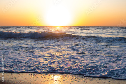 Sunset or dawn on the sea, waves and the sun.
