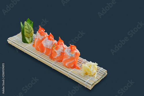 Salmon sashimi roll with sauce. Black background photo