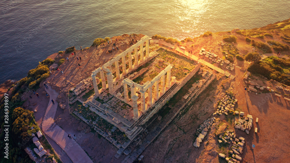 Aerial drone photo of sunset over the iconic Temple of Poseidon at Cape Sounio with amazing golden colours, Attica, Greece