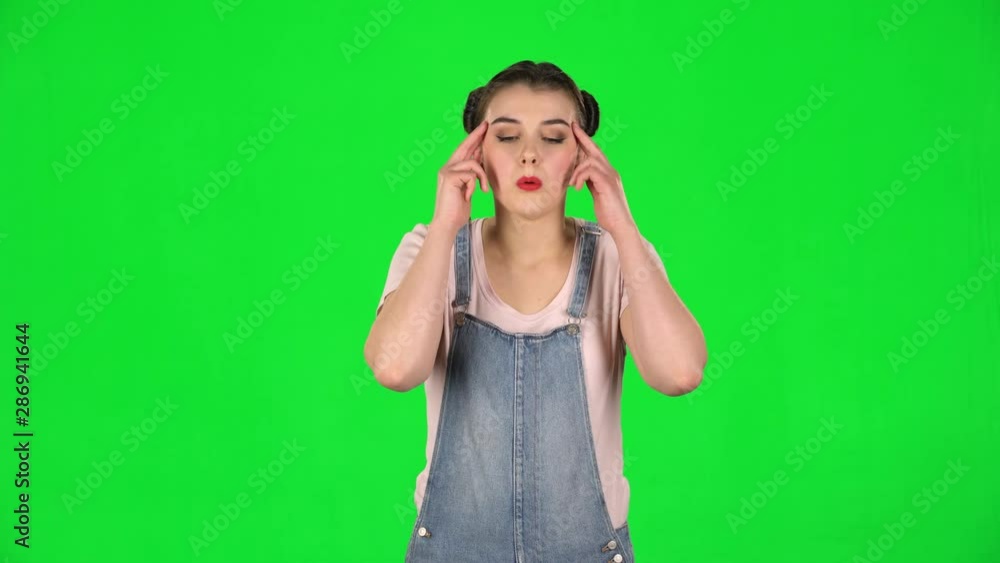 Woman suffering from headache from fatigue on green screen at studio Woman suffering from headache from fatigue on green screen at studio