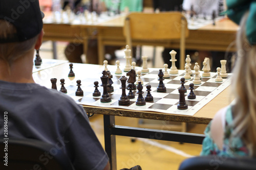 Black Chess pieces waiting for a game stock photo. Children look at chessboards time a master class. Children play chess. Black and white. 