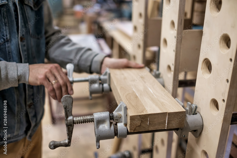 Φωτογραφία Using clamps and glue to connect wooden timbers for furniture detail