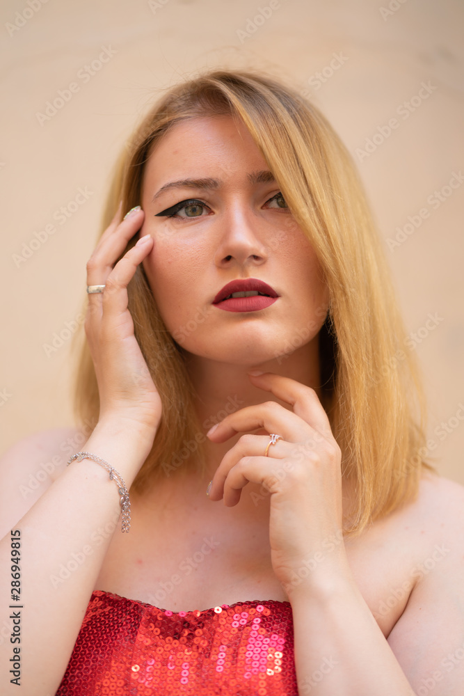 Obraz premium blonde girl with wide make up arrows on the eyes posing in the street