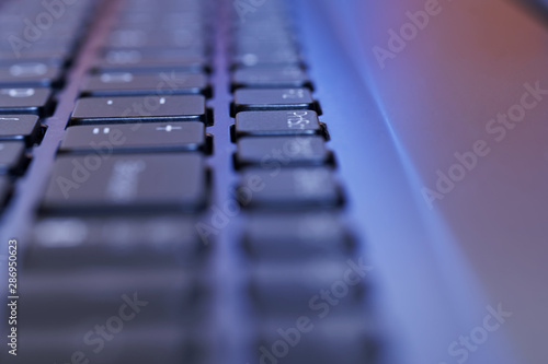 The keyboard of a modern laptop. Perspective, selective focus and shallow depth of field. Close-up