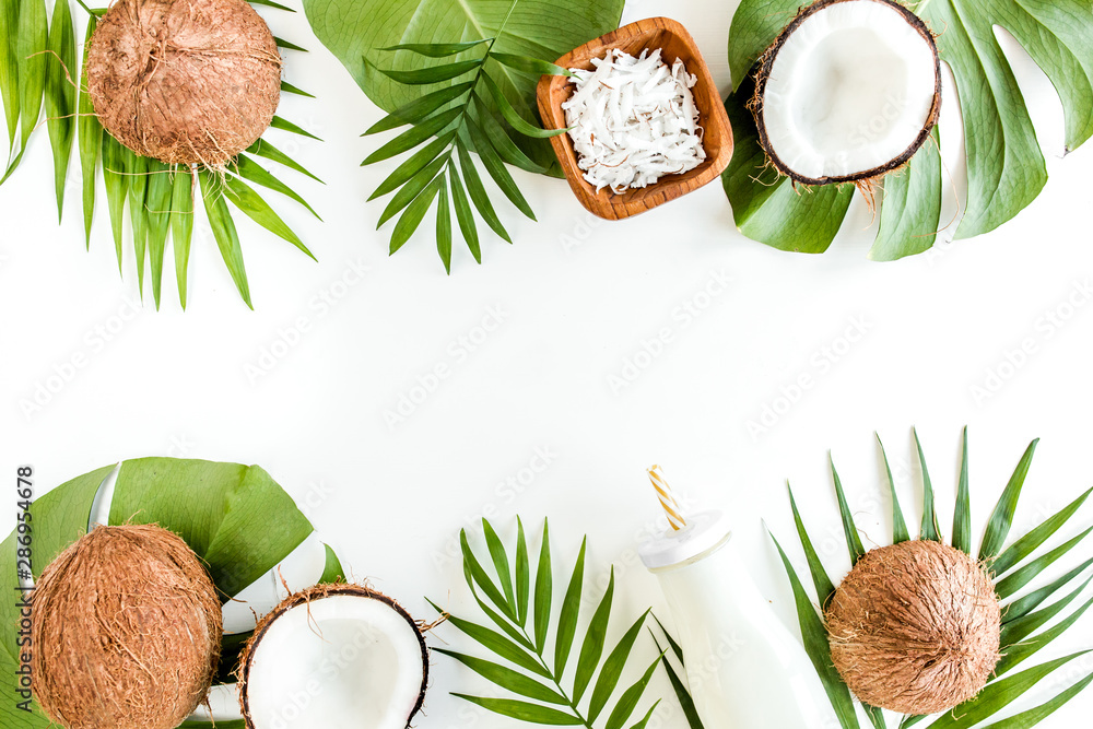 Pattern, frame borders with coconuts and tropical palm leaves on white background. Tropical abstract background. Flat lay, top view. Pattern, frame borders with coconuts and tropical palm leaves on white background. Tropical abstract background. Flat lay, top view.