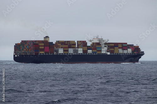 Container cargo ship moving in the ocean.