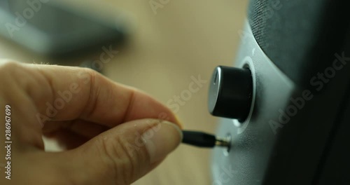 Plugging ear phone jack into speaker to listen to music on smart phone 