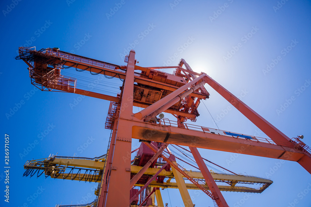 Working crane bridge in blue sky background for logistics and transportation ship. Logistic import export and transport industry background. Working crane bridge in blue sky background for logistics and transportation ship. Logistic import export and transport industry background.