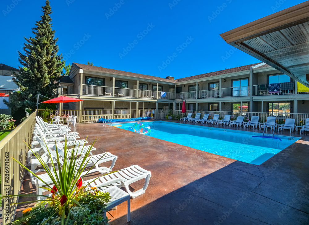 Fototapeta premium A hotel swimming pool with chaise-longues on side.