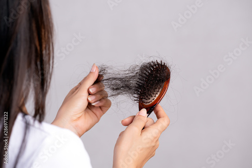 Healthy concept. Woman show her brush with damaged long loss hair and looking at her hair. photo