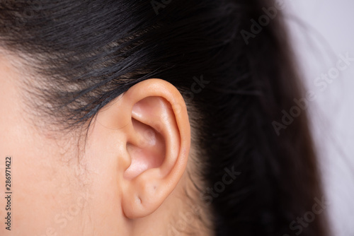 Close up young asian woman ear with Ear piercing. Healthcare and ear cleaning concept. photo