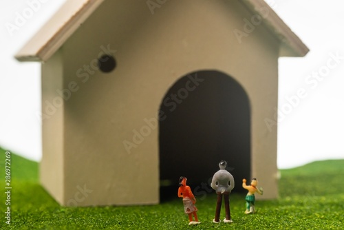 Miniature people in from of toy house. Happy family concept  a family in front of a house