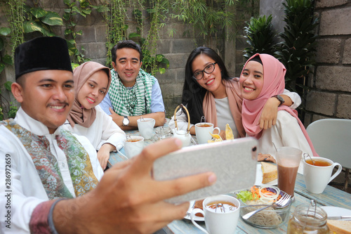 group of friends taking selfie during lunch outdoor