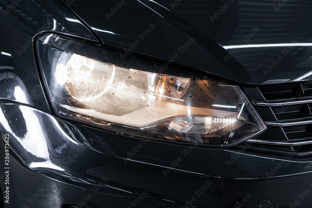 Black car headlights. Exterior detail. Close up detail on one of the LED headlights modern car.. - obrazy, fototapety, plakaty 