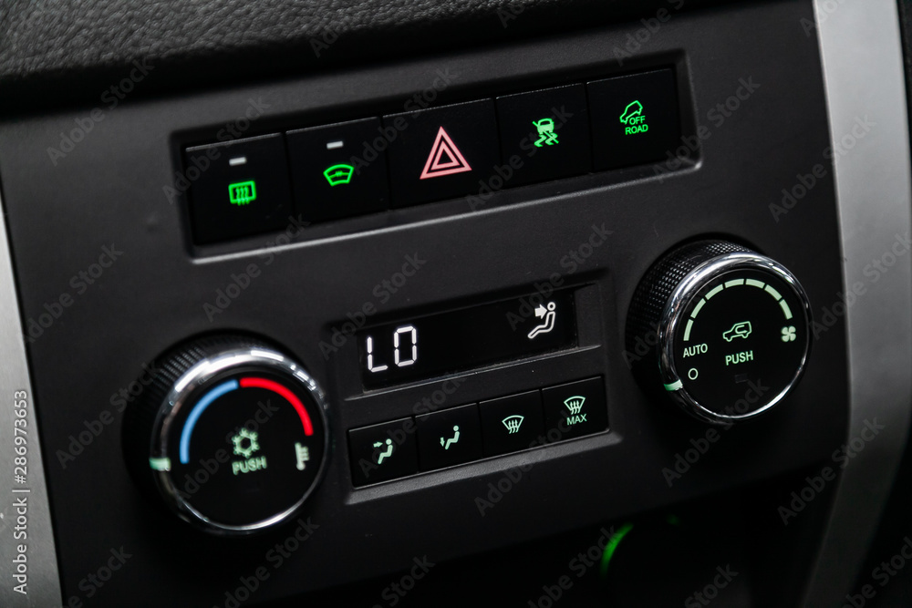 Modern black car interior: climat control view with air conditioning button, the dashboard with information about temperature inside a car.