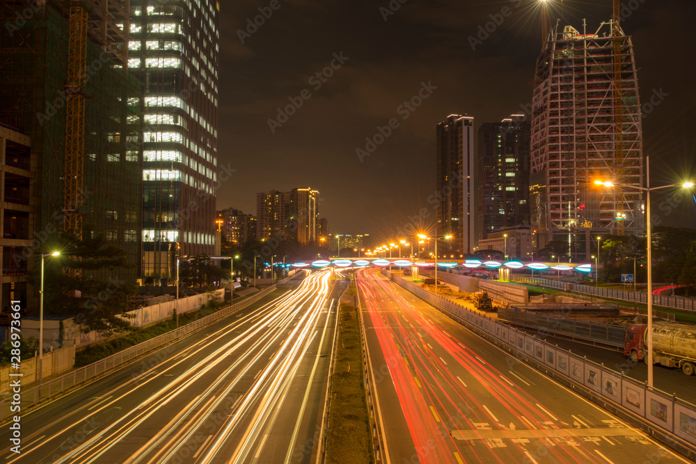 a long exposure shot on traffic light trails in downtown shenzhen at night