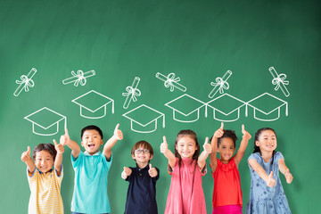 happy Multi-ethnic group of school children standing in classroom with graduation concept