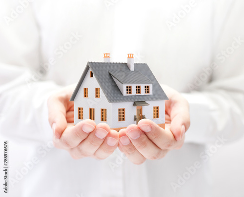 Small toy house in hands 