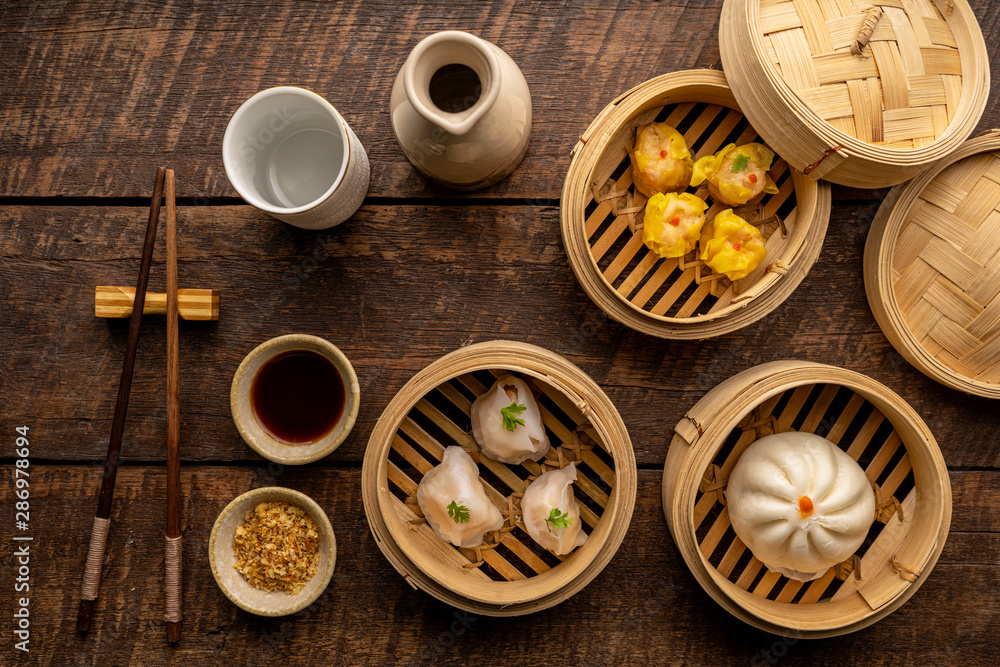 Dim sum, Dim Sum on the wooden table, top view and space for text input , Dim Sum (Chinese food) in steamed bamboo Dim sum, Dim Sum on the wooden table, top view and space for text input , Dim Sum (Chinese food) in steamed bamboo